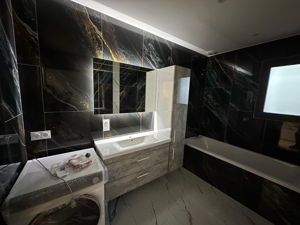 Cuisine avec aménagement en U, plan de travail en granit et crédence en verre